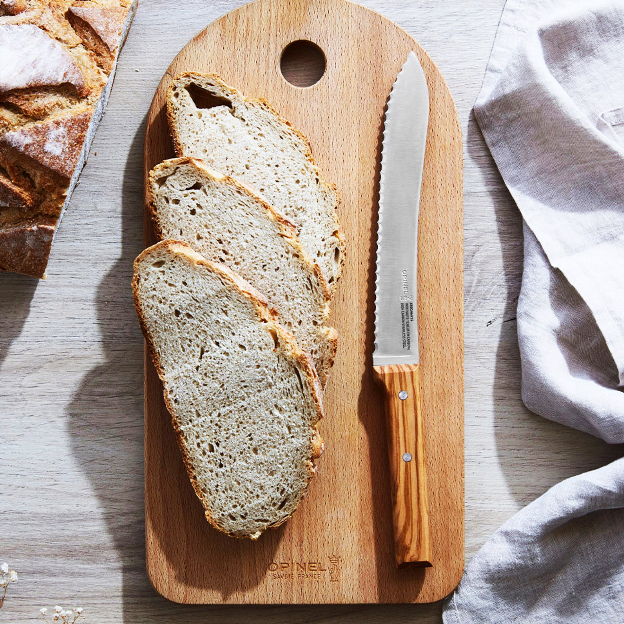 Opinel-Linkshaender-Brotmesser-PARALLELE-No-116-holz-griff-olivenholz-3123840024955-Anwendung-brotmesser-auf-brett-lafueliki